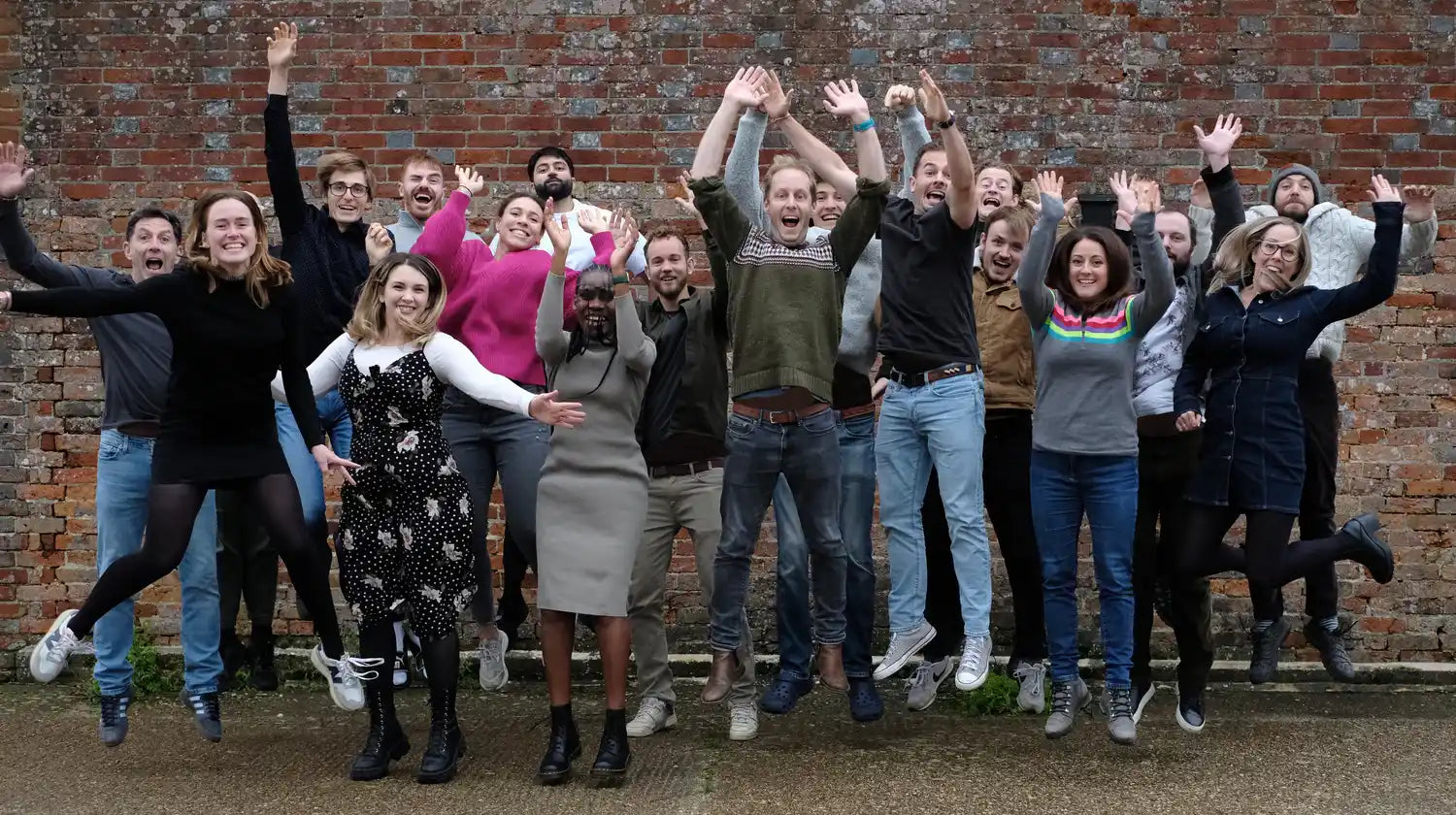 group of people smiling and jumping in the air