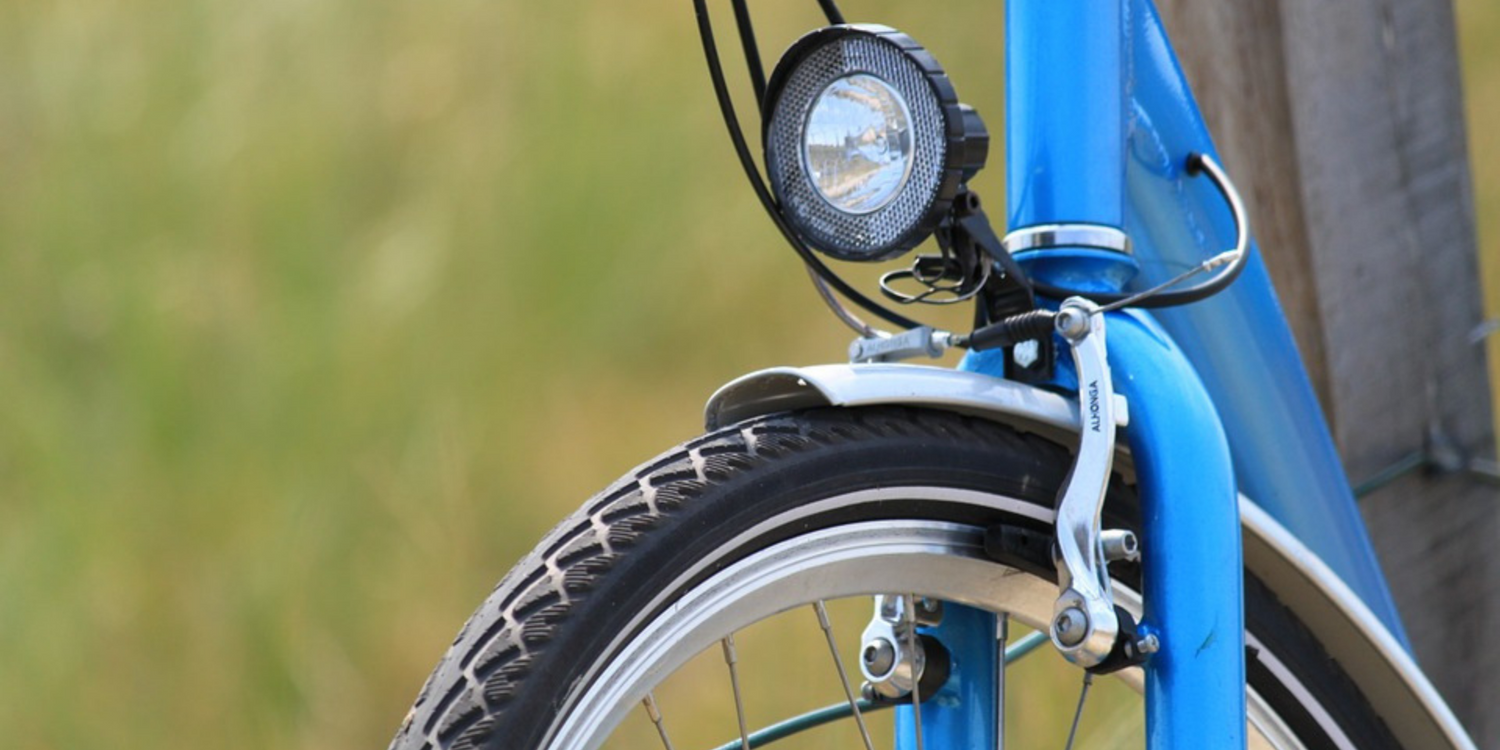 Close up of front bike light on blue bicycle